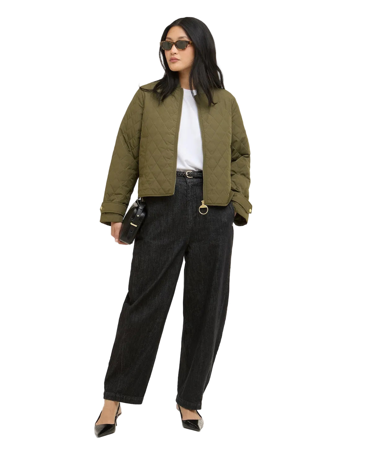 Woman wearing an olive green quilted jacket and dark pants on a white background