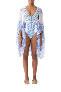 Woman wearing a blue and white patterned cover-up dress on a white background