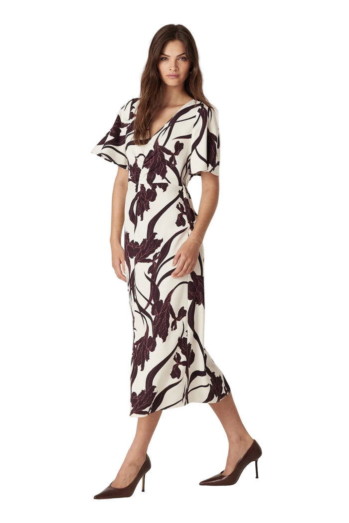 Woman wearing a black and white floral dress on a plain background