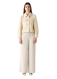 Woman wearing a beige jacket and pants on a white background