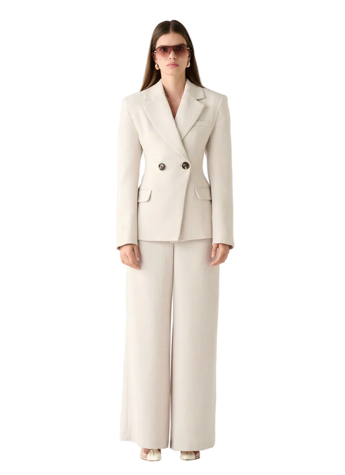 Woman wearing a beige suit on a white background