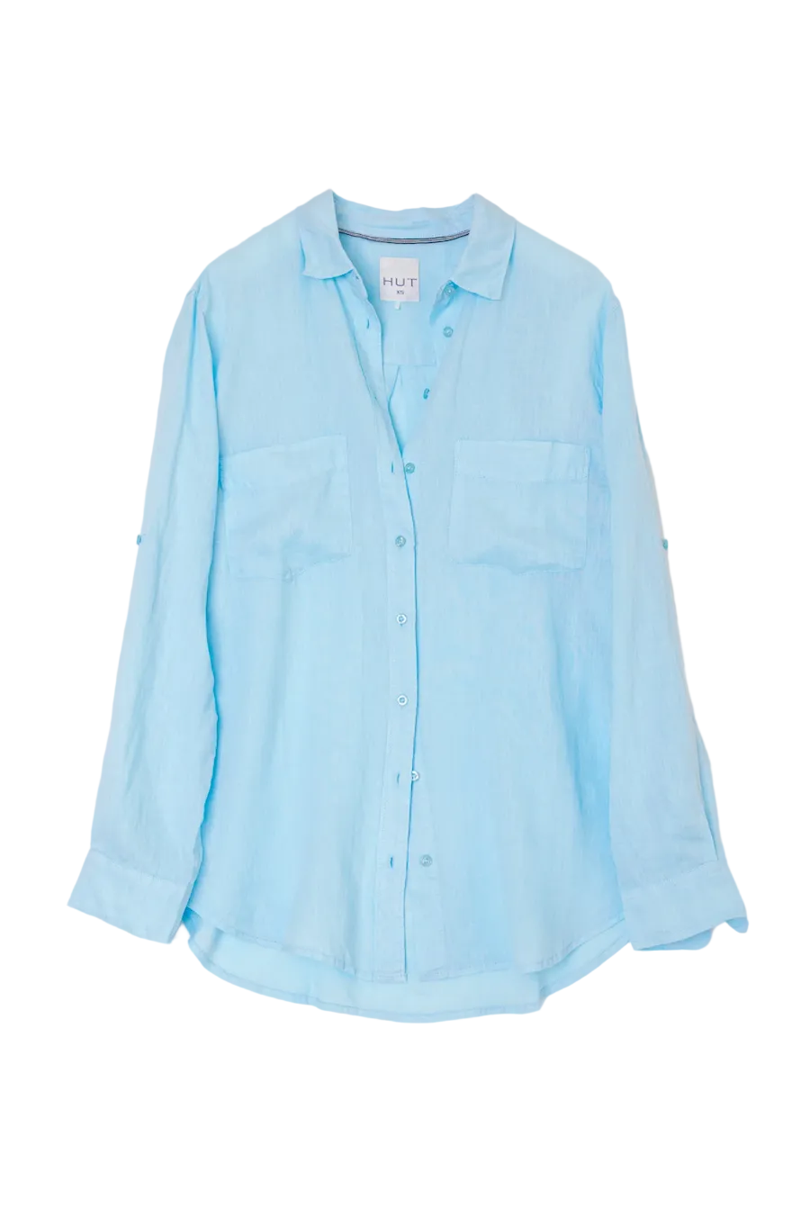 A light blue long-sleeve button-up shirt with two chest pockets, laid flat against a light gray background.
