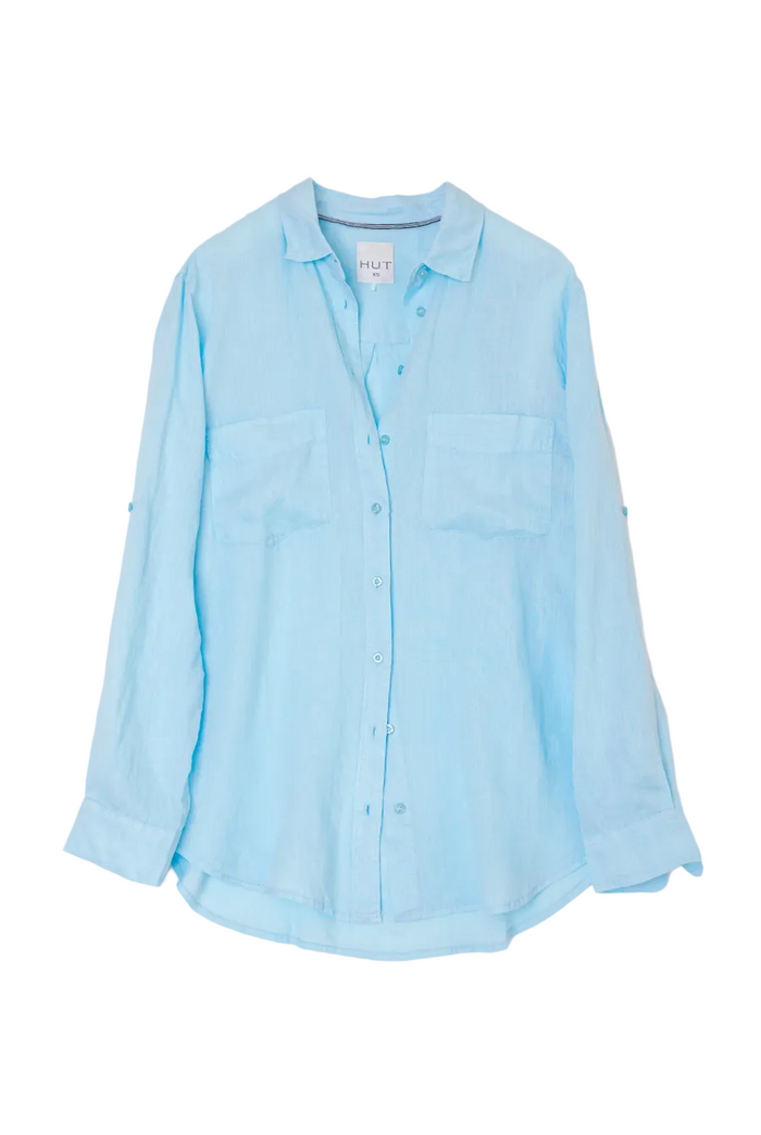 A light blue long-sleeve button-up shirt with two chest pockets, laid flat against a light gray background.