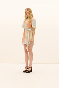 Woman wearing a patterned dress on a white background